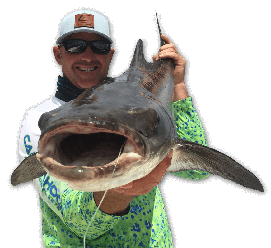 An image of a fisherman with a cobia pointed right at the camera, taken on a Tidewater charter. 