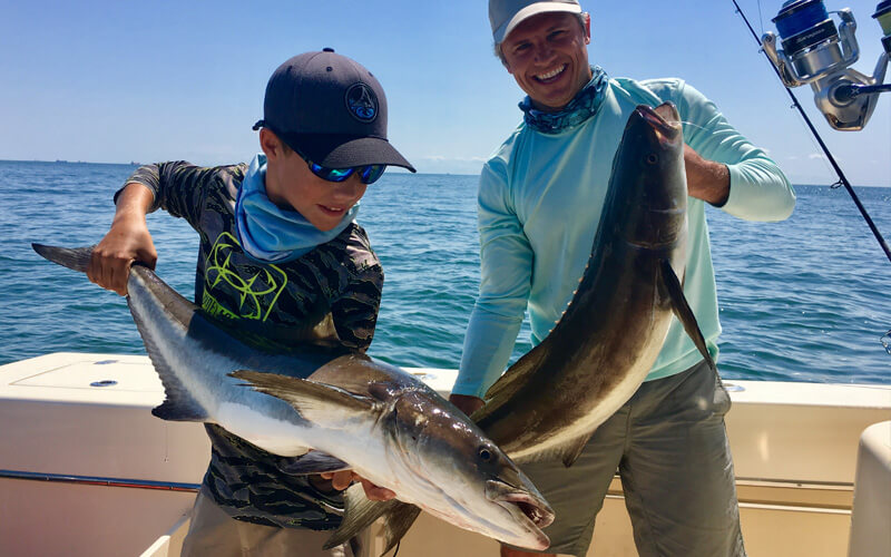 An image of a father and son angling team with cobia caught on board a tidewater charters adventure. 