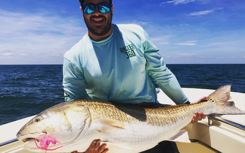 An image of an angler with a monster redfish aboard a Tidewater Cape Charles fishing charter adventure.