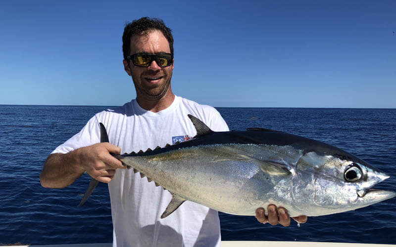 An image of an angler with a blackfin tuna caught on a Florida Keys fishing charters with Tidewater Charters. 